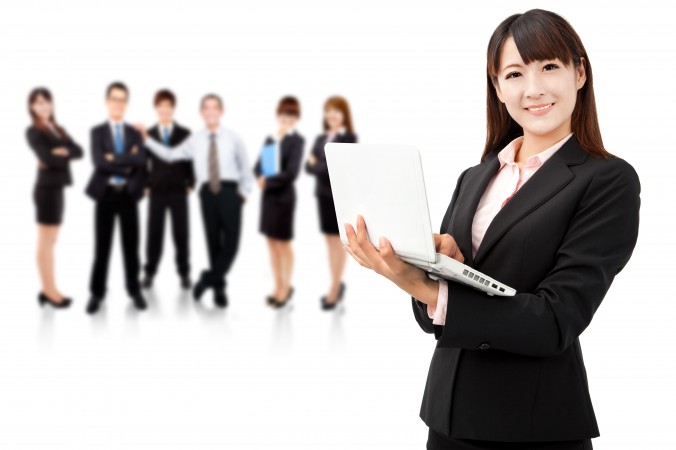 businesswoman holding laptop and business team